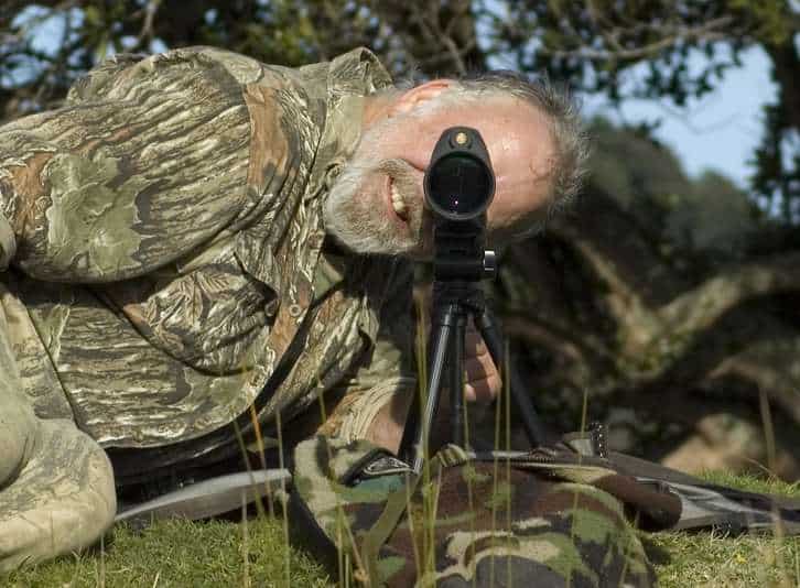 Hunter lying down looking through spotting scope
